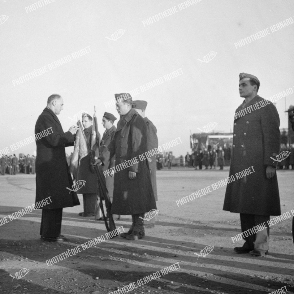 F091 Le Ministre de l'Air du gouvernement Charles de Gaulle Charles Tillon décore les fanions des groupes Maroc, Bretagne, Gascognes, 02/12/1944 à Bron. MARAUDERS B26 FRANÇAIS.